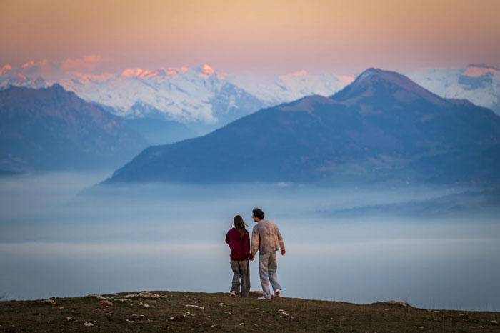 Deux personnes contemplant les Alpes au coucher du soleil depuis le Salève