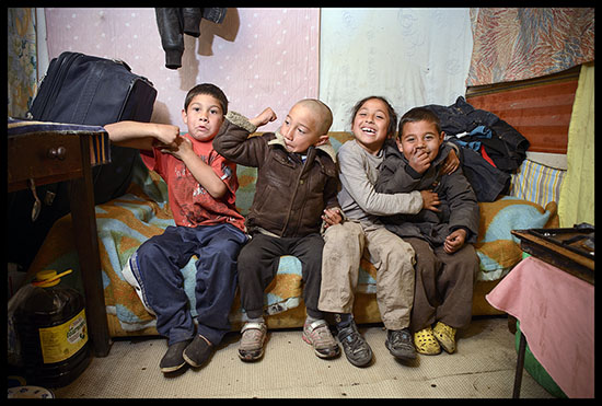 Enfants roms assis sur un canapé qui rigolent