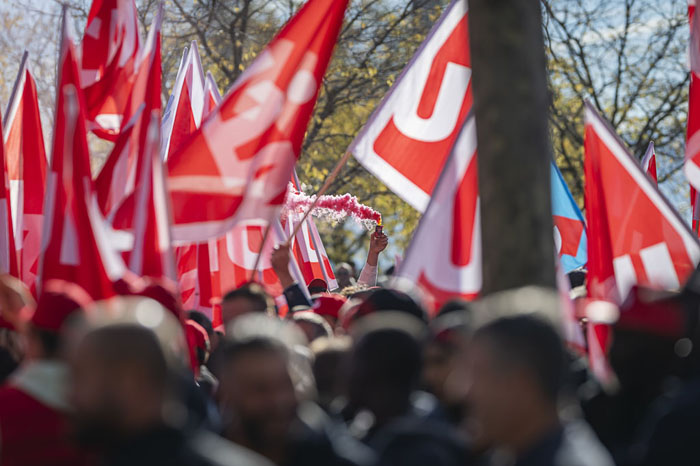 Manifestation des maçons à Genève avec une foule de grévistes et des drapeaux syndicaux rouges